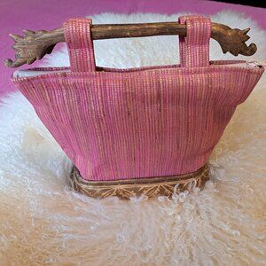 Vintage pink Bali cloth purse with carved wood handles and base.
